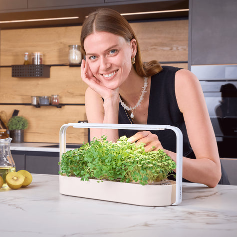 Glückliche Frau mit ingarden Garten in eleganter Küche